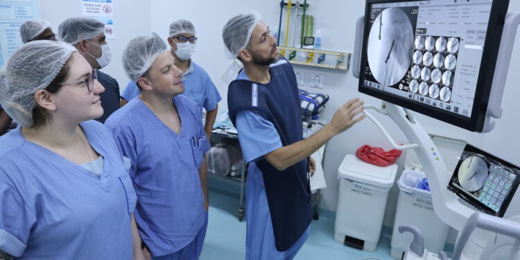 Médicos e técnicos em radiologia observam parafuso em quadril de paciente durante treinamento com novo arco - Foto: Adenir Britto/PMSJC