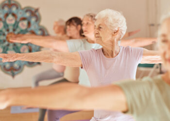 pessoas da terceira idade fazem exercicios desfrutando dos benefícios da yoga para idosos