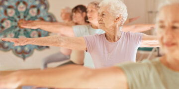 pessoas da terceira idade fazem exercicios desfrutando dos benefícios da yoga para idosos