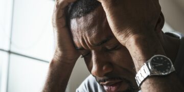 "Homem com expressão de eansiedade segurando a cabeça