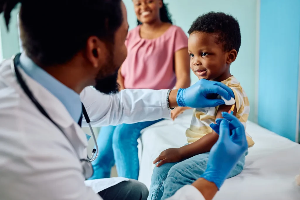 criança cumprindo a caderneta de vacinação|exemplar da caderneta de vacinação|bebê tomando vacina
