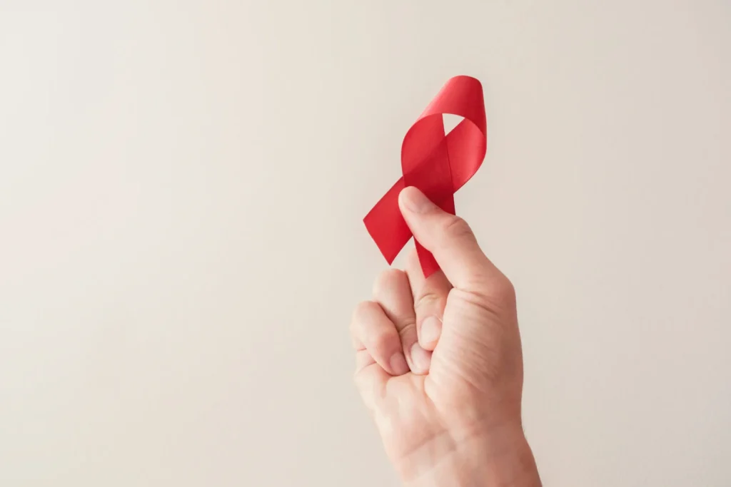 fita vermelha simboliza diferença entre hiv e aids|fita vermelha na mão