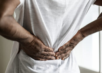 Pessoa com dor nas costas segurando a lombar