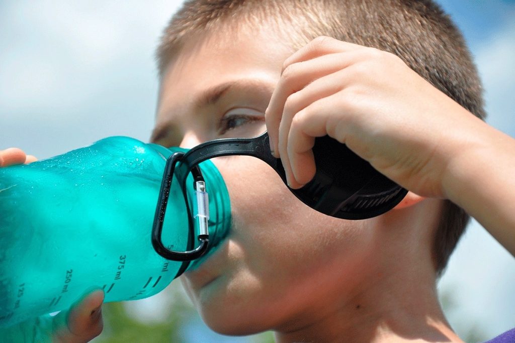 |woman drinking water from glass bottle 500