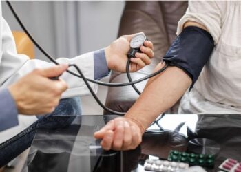 Profissional de saúde medindo a pressão arterial de paciente com esfigmomanômetro