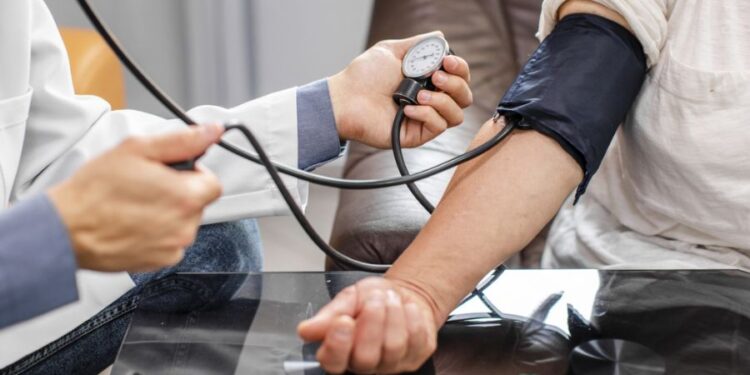 Profissional de saúde medindo a pressão arterial de paciente com esfigmomanômetro