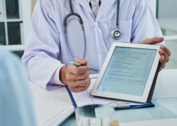 Médico mostrando questionário em tablet durante consulta