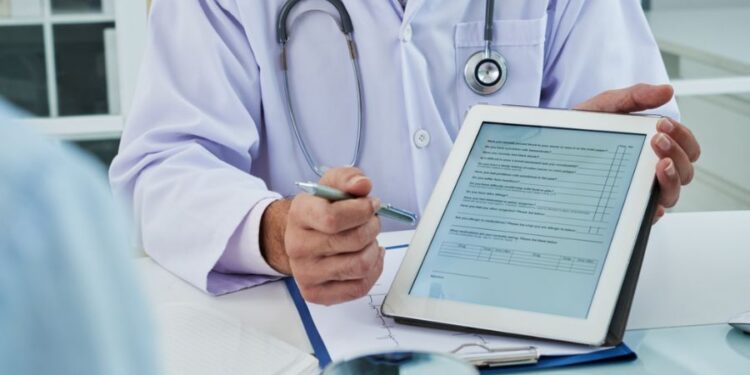 Médico mostrando questionário em tablet durante consulta