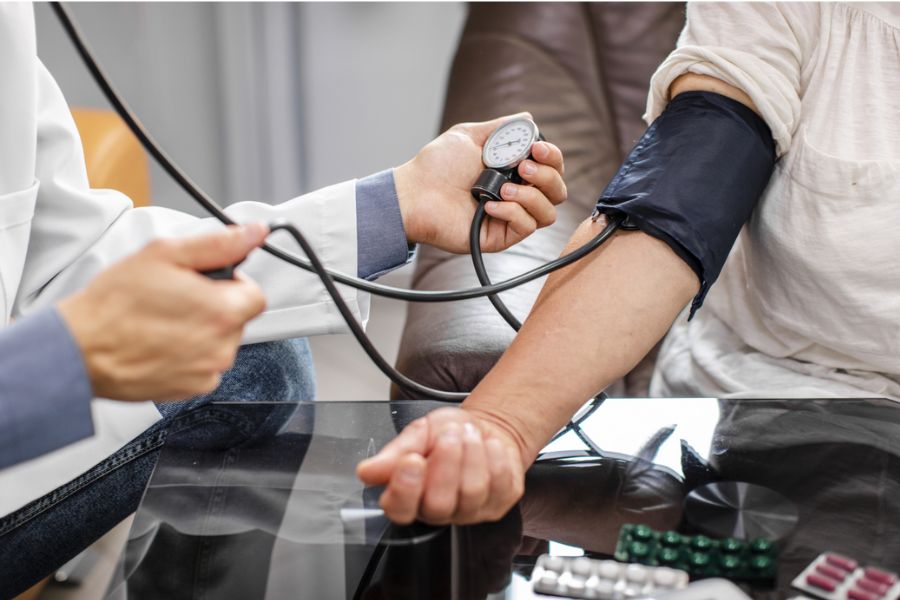 Profissional de saúde medindo a pressão arterial de paciente com esfigmomanômetro