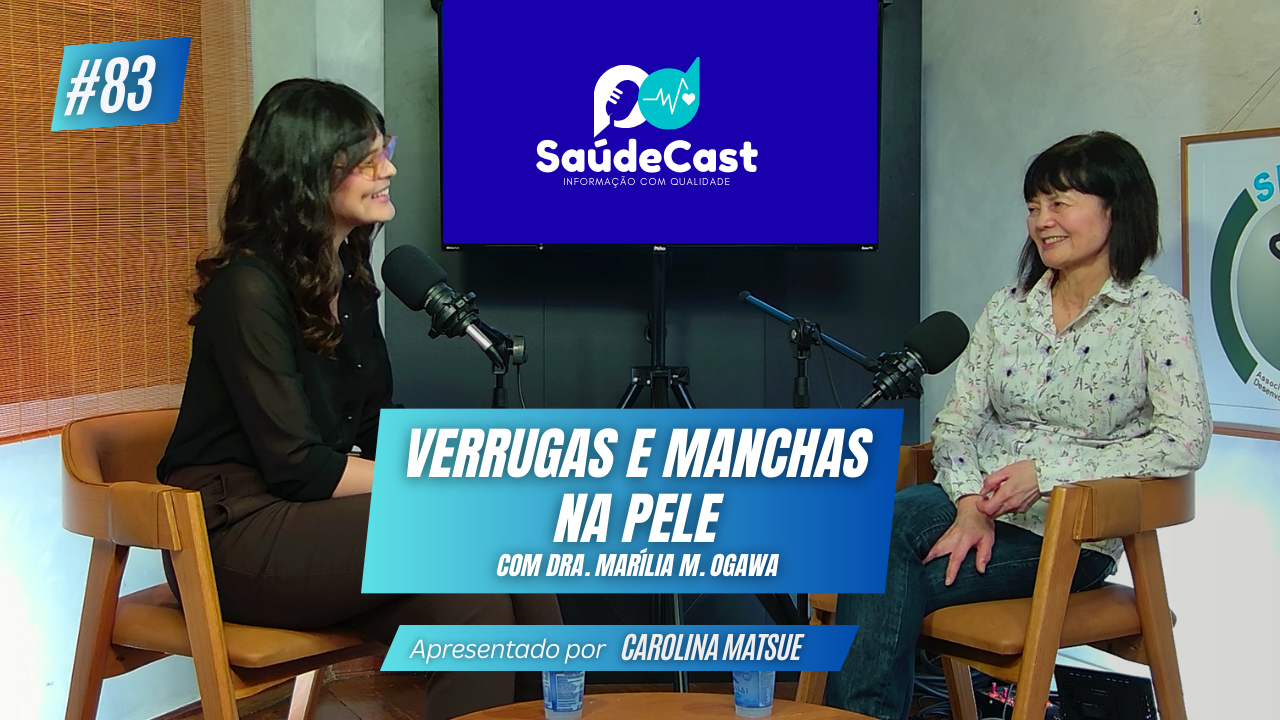 Foto em estúdio do SaúdeCast em podcast sobre Verrugas e Manchas na Pele. Carolina Matsue e Dra. Marília Ogawa sentados em cadeiras.