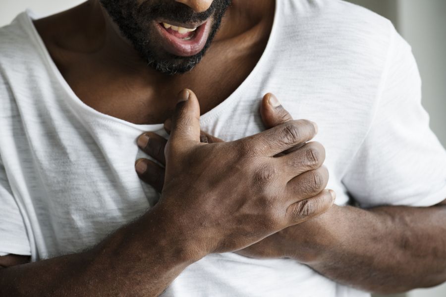 Homem segurando o peito demonstrando desconforto.