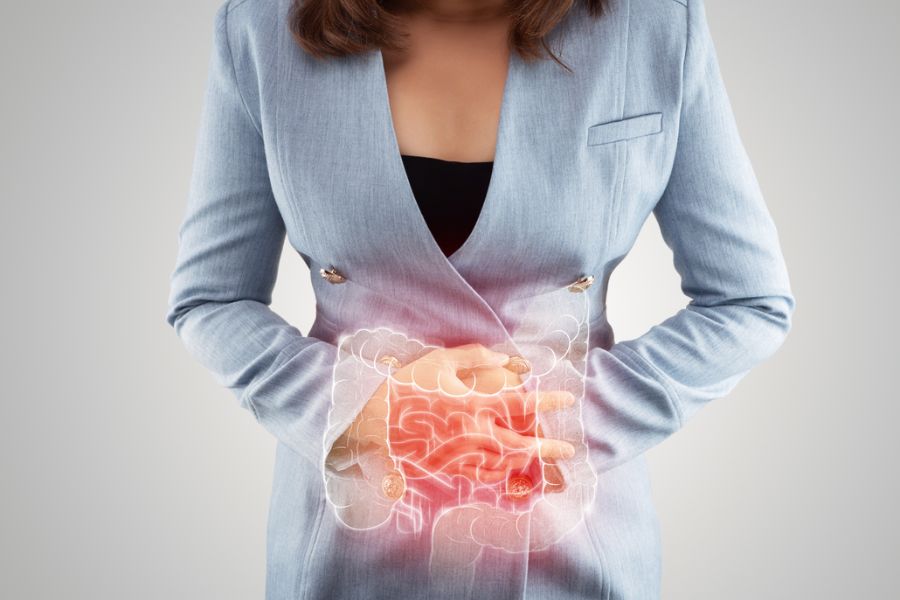 Mulher com dor abdominal destacando a região intestinal.