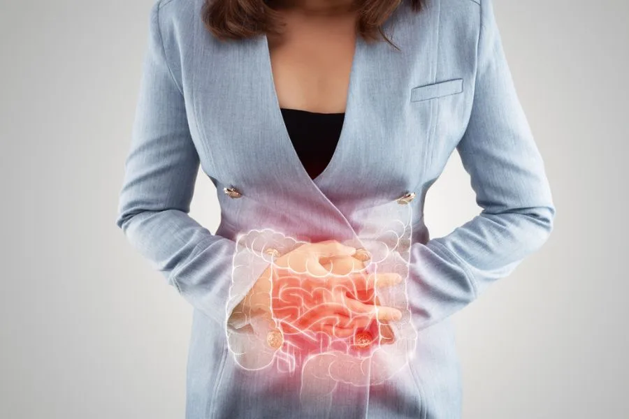 Mulher com dor abdominal destacando a região intestinal.